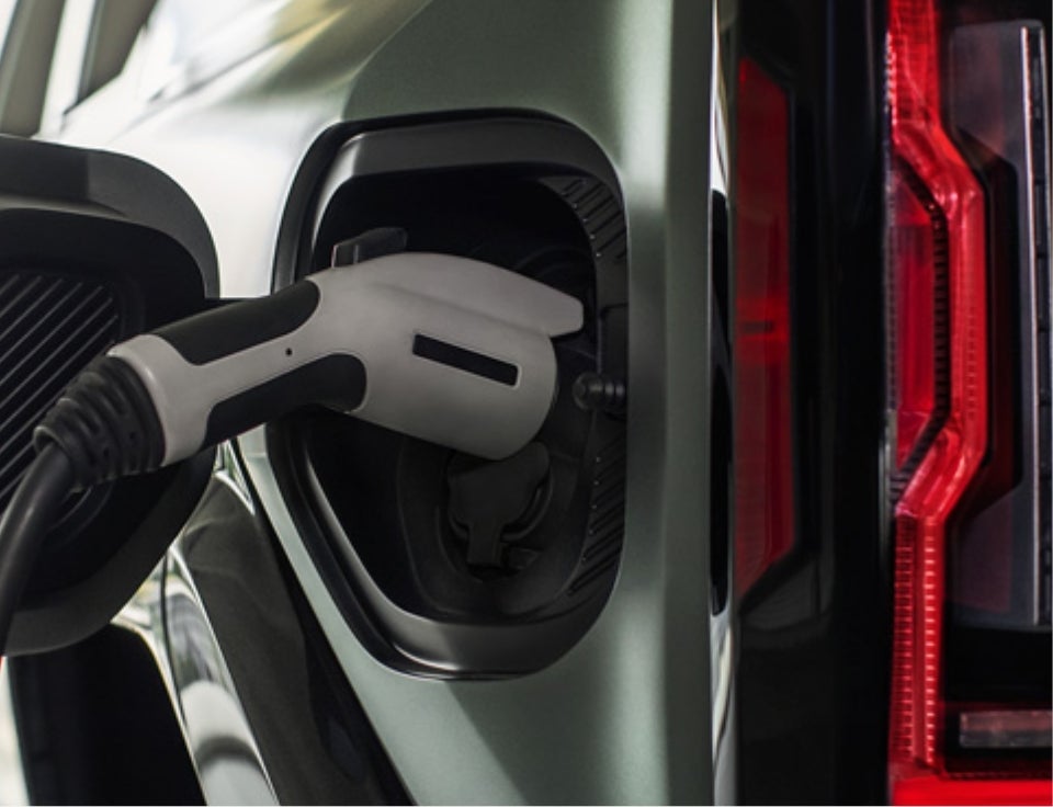 Close up of charging port with charger plugged in on a GMC Hummer EV SUV - Tuck's Trucks GMC in Hudson MA